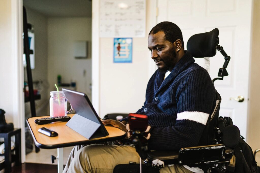 A man in a wheelchair using his laptop.