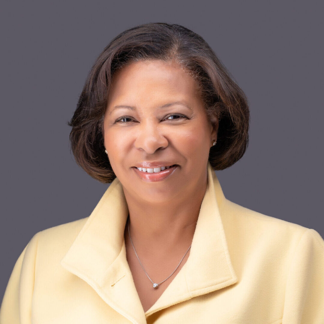 A woman in yellow jacket smiling for the camera.